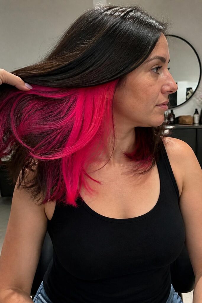 2. Neon pink streaks on dark hair