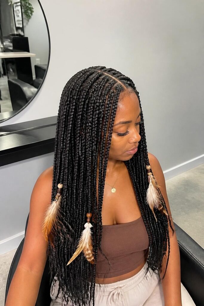 Long boho knotless braids with feather accents