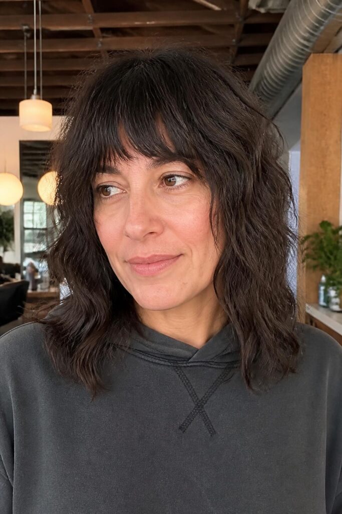 10. Medium wavy hair with choppy bangs