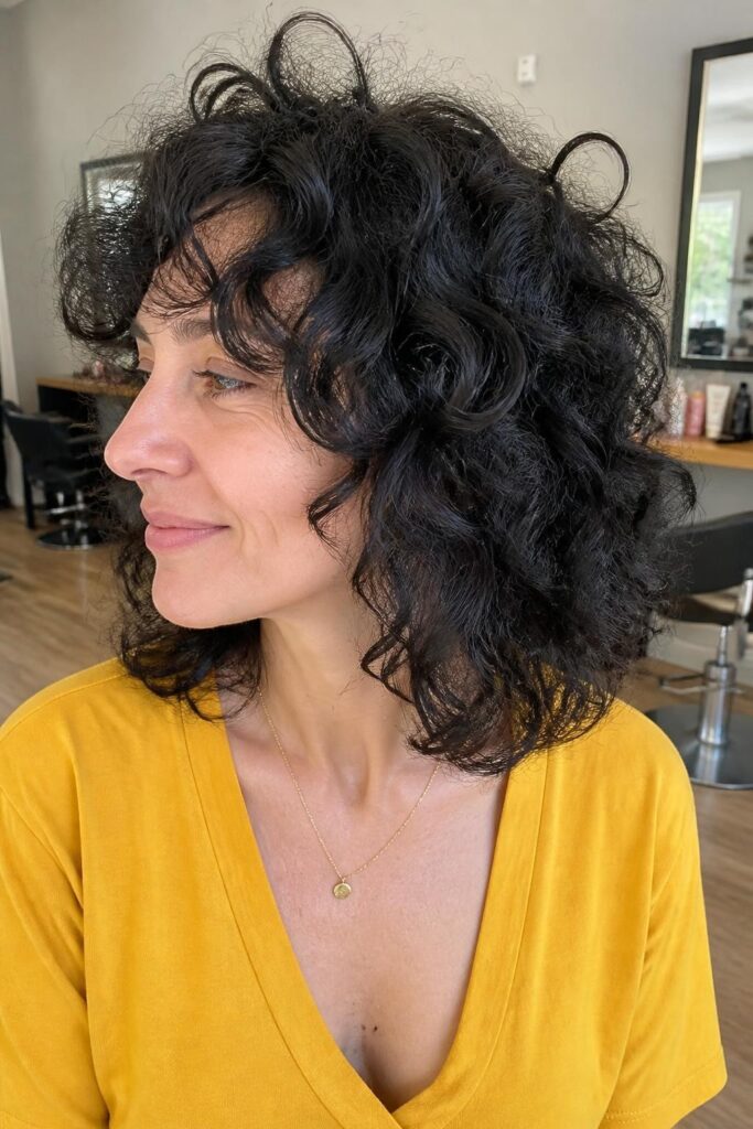 6. Curly medium cut with curtain bangs
