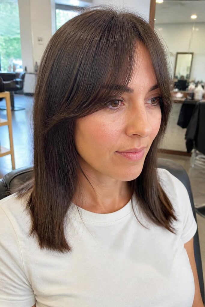 9. Medium straight hair with arched bangs