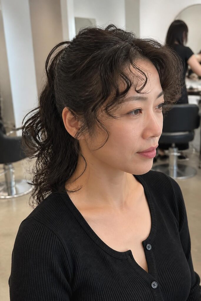 Half pony with face-framing curly bangs