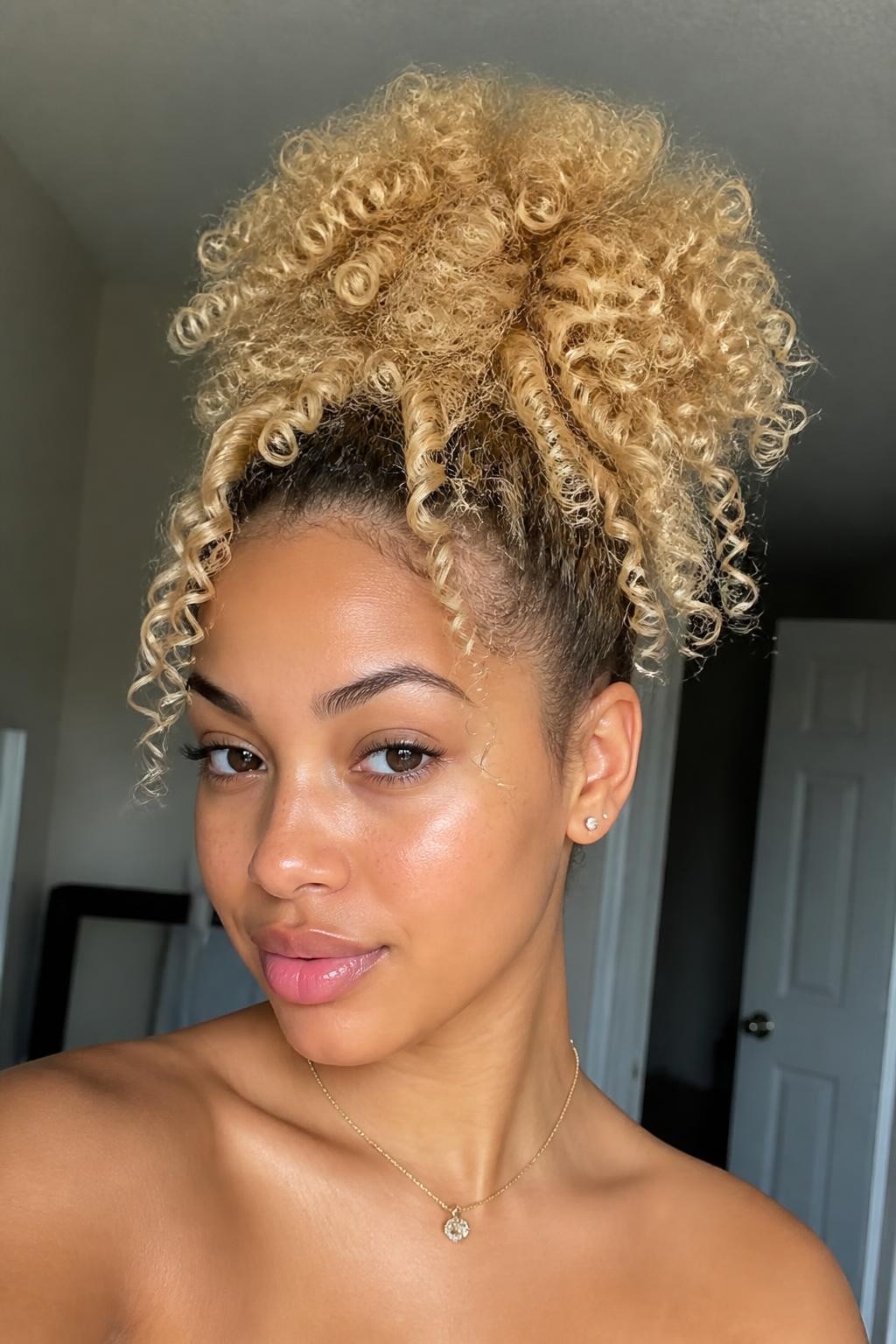 Woman with butter blonde high puff with curls