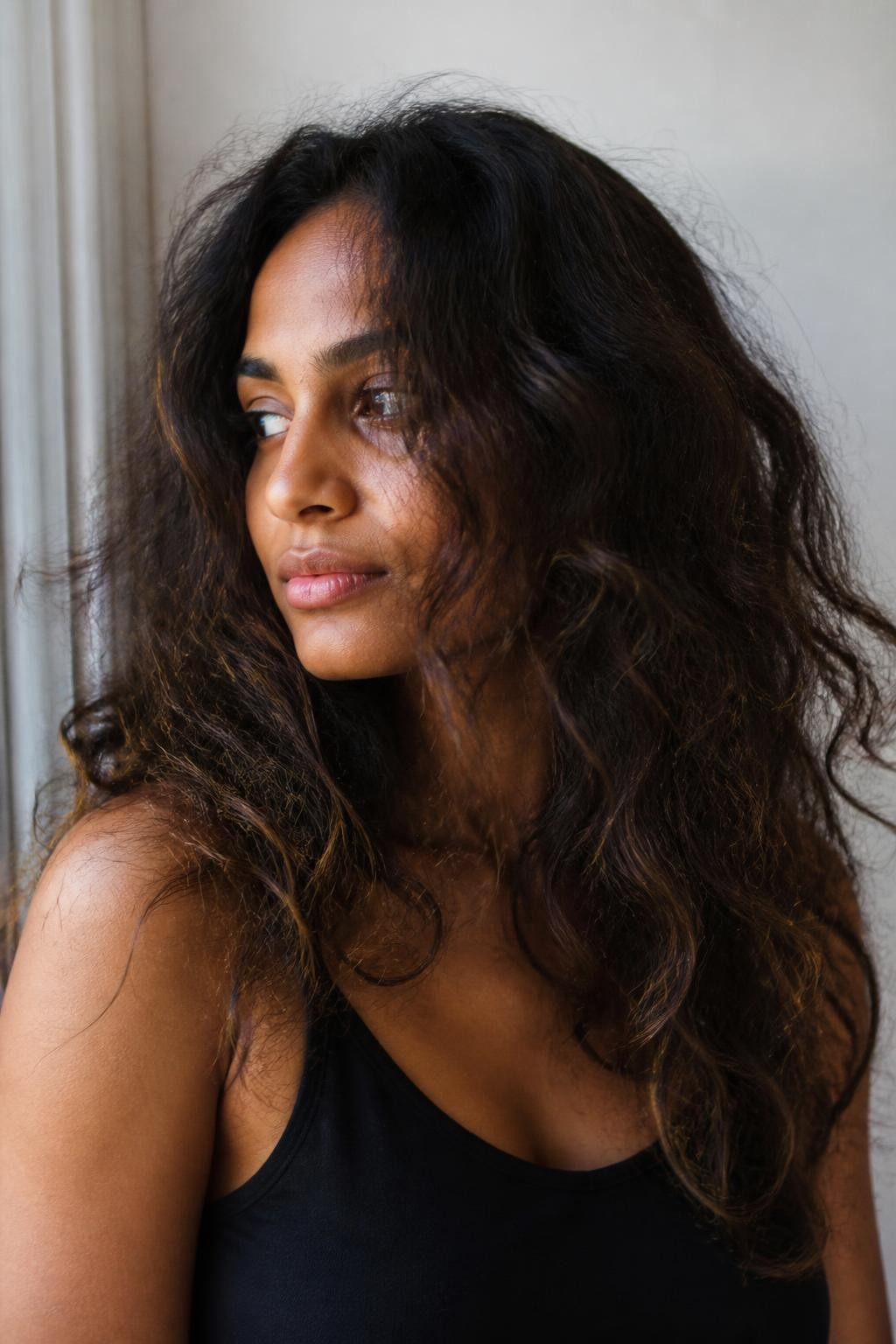 Woman with air-dried frizzy wavy hair with visible texture and halo frizz