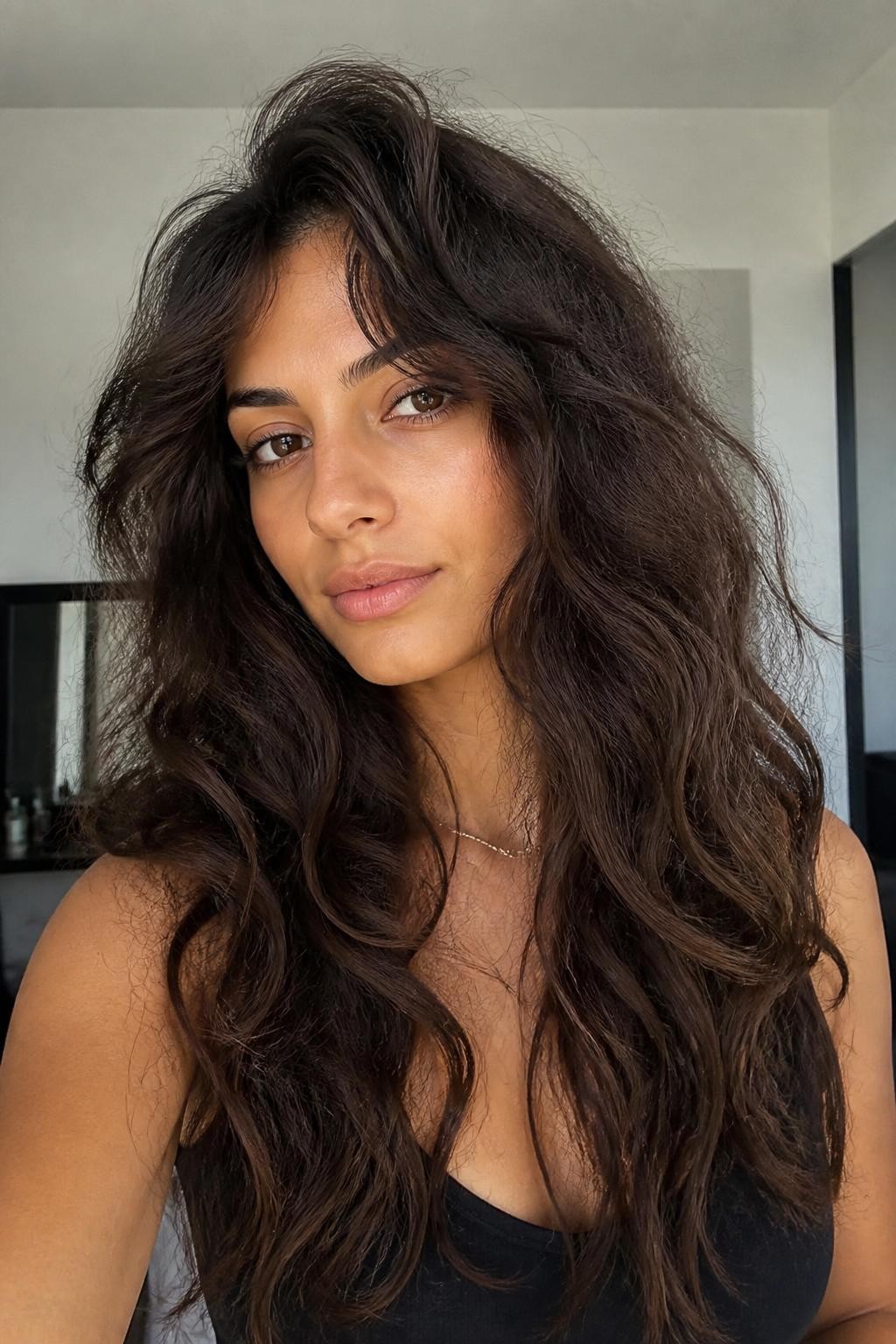 Woman with long layered haircut on frizzy wavy hair with visible frizz
