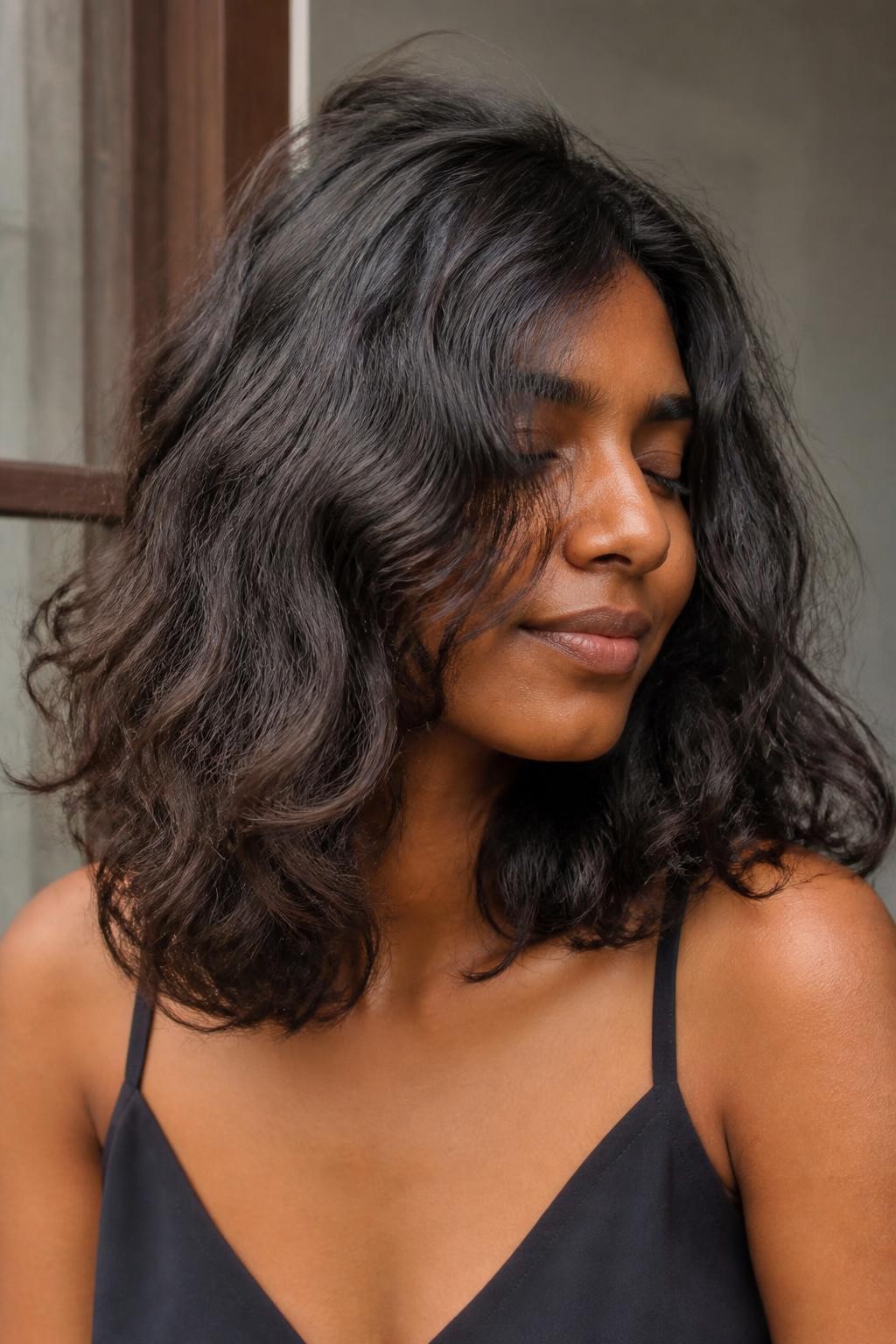 Woman with shoulder-length frizzy wavy hair with halo texture