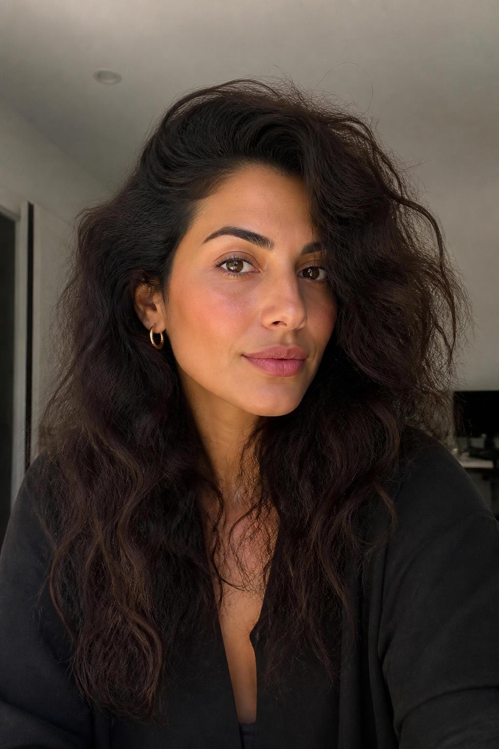 Woman with deep side part on frizzy wavy hair with visible texture
