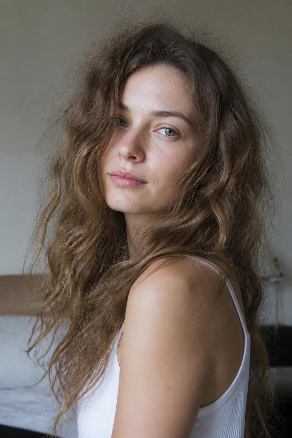 Woman with lived-in low-maintenance frizzy wavy hair with natural halo frizz